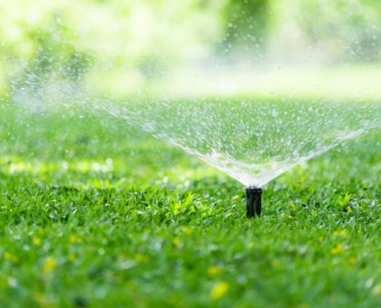 aspersor-automatico-cesped-jardin-accion-regando-pasto_103077-3